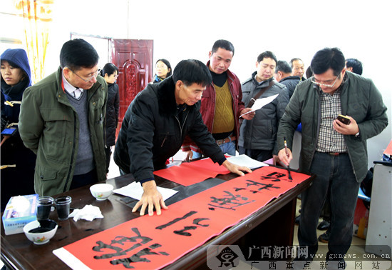 书法家在广西灵山县旧州镇那良村为村民义务写春联.