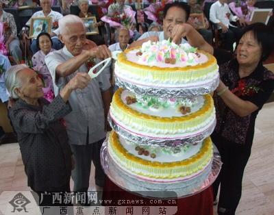 钻石婚,金婚夫妇代表切庆典蛋糕.记者  伍永志摄