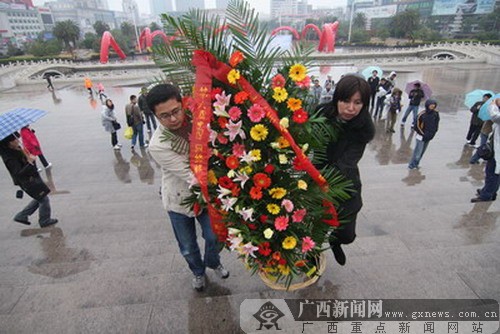 和工作人员来到南昌八一广场,向坐落在这里的八一起义纪念碑敬献花篮
