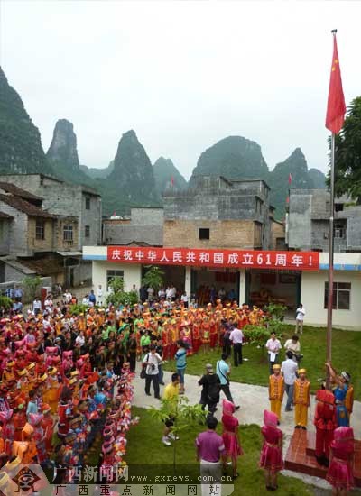 邓达)10月1日早上,随着朝阳升起,马山县古寨瑶族乡民兴村数百名村民