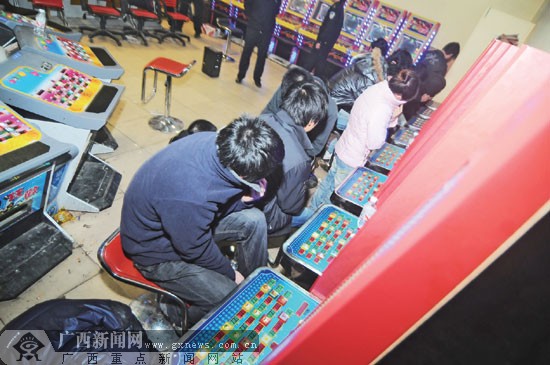 涉赌人员躲避记者镜头 广西新闻网讯(记者 黄有宁 文/图)7日晚,南宁市公安局邕武派出所对辖区的赌博游戏机室进行查处,缴获一批赌博游戏机,抓获一批涉赌人员。在这次行动中,一些曾经遭到警方查处的赌博游戏机室“死灰复燃”。赌博游戏机室为何难以根除呢? 在望州南路金桂花园小区门口右侧有一家奶茶店,如果没有人介绍,一般人根本就不可能知道其中的秘密——奶茶店别有洞天,里面暗藏赌博游戏机室。 “你看这扇门,装得像是墙壁一样。”记者看到,奶茶店