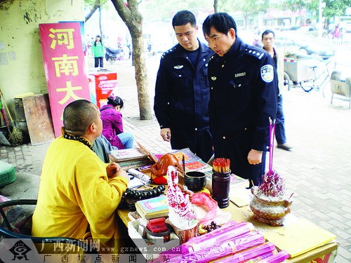 男子穿袈裟闹市区摆摊"算命" 闲时西装革履叼烟卷
