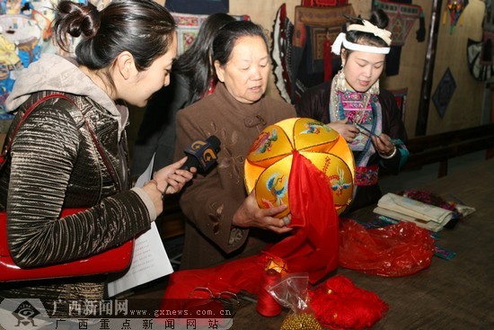 工艺大师在介绍绣球等传统织绣的制作细节.广西新闻网记者 邓昶摄
