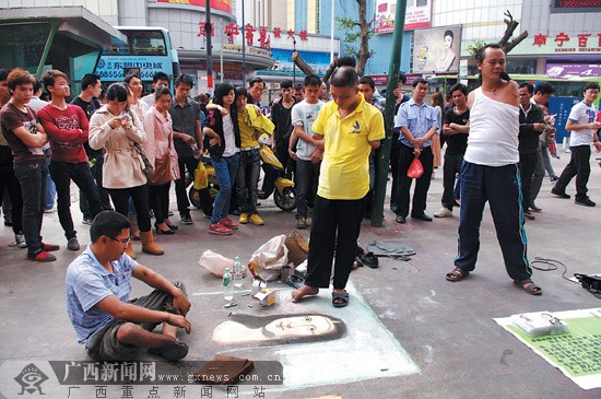 3名残疾人在街头卖艺吸引人群捧场,从左至右分别是宋群,程义和邱举.