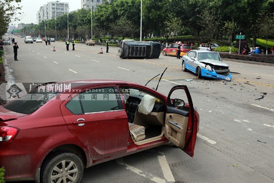 图为车祸现场,出租车和小轿车迎面相撞,严重受损,画面远处是侧翻的