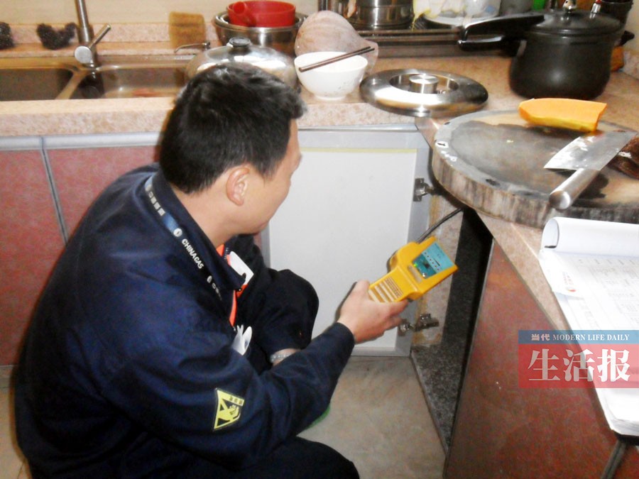 安检员使用可燃气体探测器为住户做微漏检查