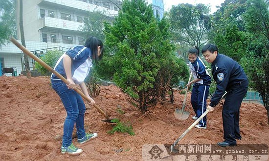 植树节交警与学生一起种树.通讯员潘钰琴 摄