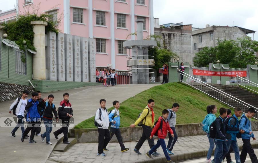 4月7日,在柳城县文昌小学,一群小学生从学校在放学后走出学校大门.