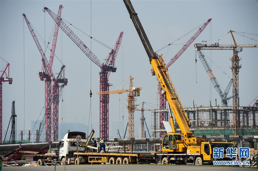 港珠澳大桥珠海口岸联检大楼建设工地塔吊林立、一片繁忙(4月29日摄)。 五一小长假期间,港珠澳跨海大桥的建设现场一片繁忙气象,大桥的建设者们坚守在各自岗位上,为大桥主体工程全线合龙贯通进行冲刺。新华社记者刘大伟摄