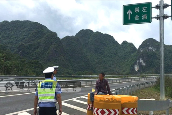 男子坐在高速路上悠闲候车 已被交警及时劝离(图)