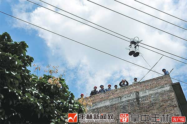玉林供电局首次启用机器人作业充当粉刷匠。 玉林新闻网-玉林日报讯(记者 曾昶 通讯员 卢志 甘春玲)快看那,电线上有机器人!随着一阵吧嗒,吧嗒的声音响起,只见高高的架空电力线路上悬挂着一个自动行走的粉刷匠机器人,玉东新区茂林镇大虫隆村村民立即被这场景所吸引,纷纷围过来看新鲜。这是6月11日,玉林供电局对10千伏金谷榕楼线的线房隐患进行整治的情景。 随着玉林经济社会的发展,城区内居民自建房逐渐增多,配电线路与房屋的安全距离不满足安全运行要求的安全隐患事件也随之增加,存在着人身触电
