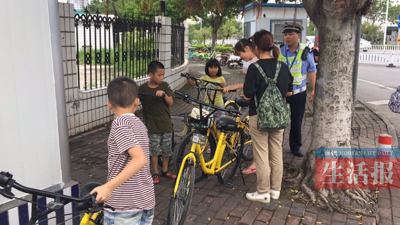 3名儿童骑共享单车上路 交警:未满12周岁不能