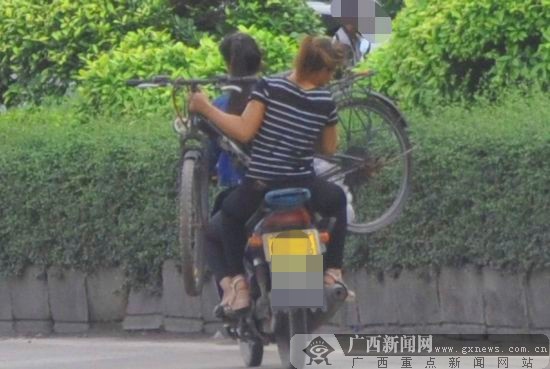 乘客坐摩托车扛自行车 "大力士"被交警叫停(图)