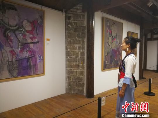 一位姑娘正在观看展出的作品。 主办方供图