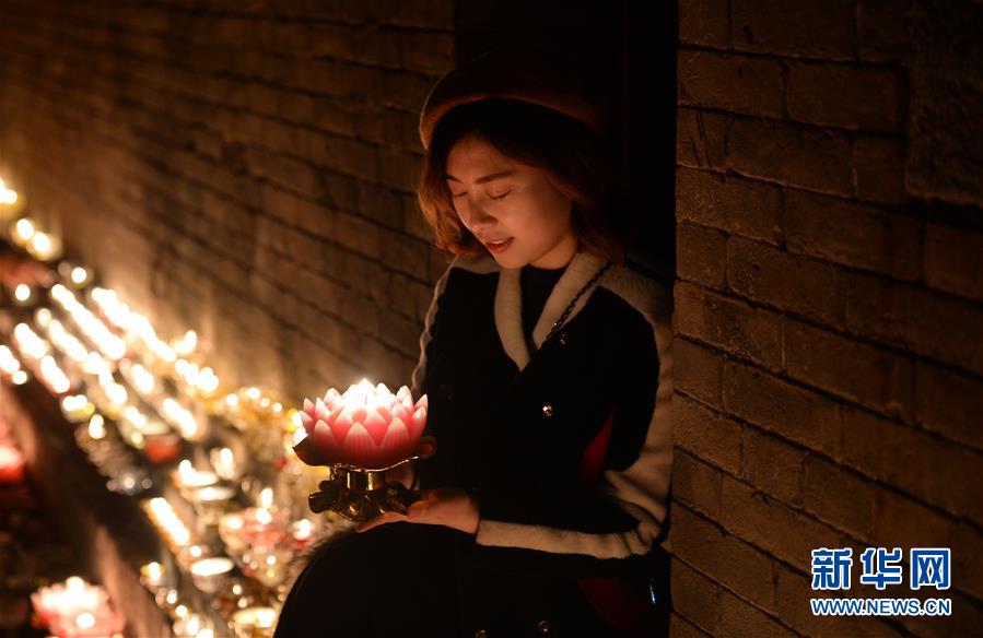 一名游客在西安广仁寺手捧酥油灯祈福(2月23日摄.