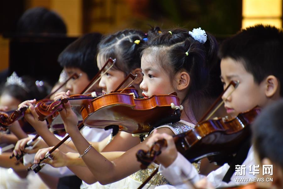 7月29日,来自北京宋庆龄和平天使艺术团弦乐团的孩子们在表演小提琴