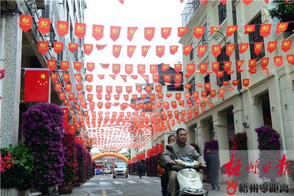 12月9日,龙母庙门前的道路挂起国旗和彩旗,摆满鲜花.