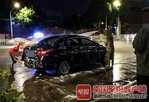 马路洗车点的污水污染了近半幅路面.(图源:南国早报客户端)