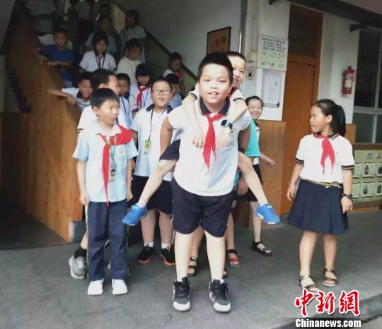 小躯体散发＂超人＂热量！浙江一小学生背同学上课