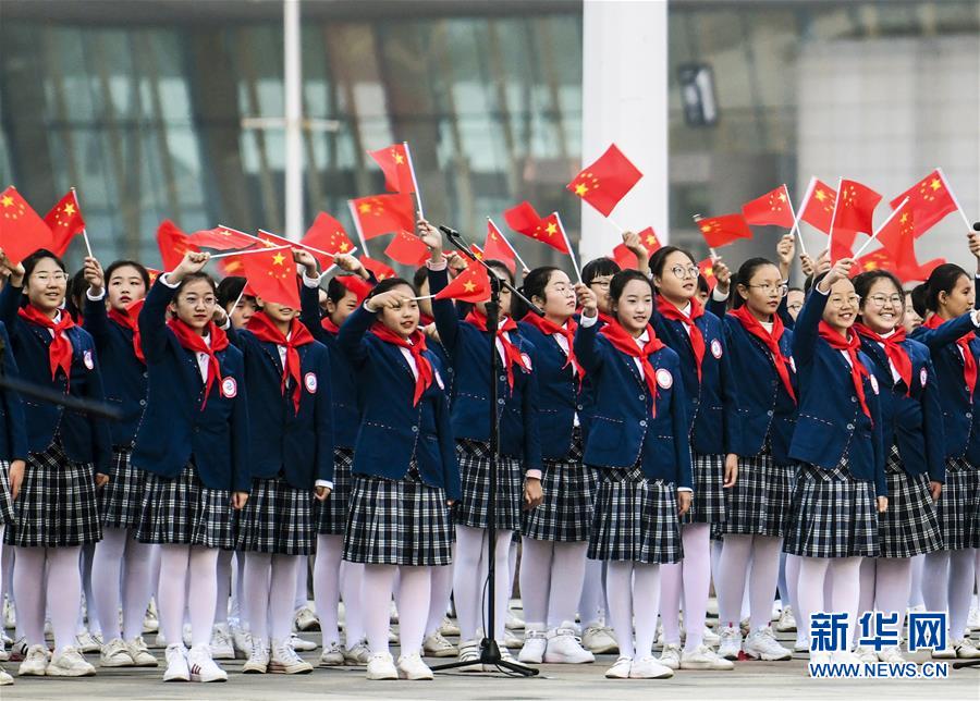 10月1日,青少年在新疆乌鲁木齐市参加国庆升旗仪式.