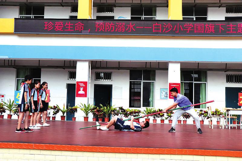 南宁市江南区白沙小学师生演示正确的溺水施救方式.周珈杏摄
