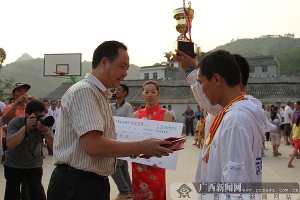 大化县委书记韦朝永给获得冠军的河南清华钓具队颁奖.