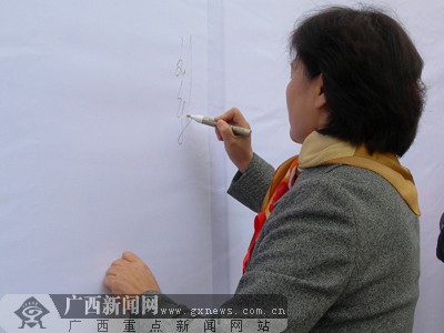 刘新文在"遏制艾滋,履行承诺"万人签名上签名.肖洋桂摄