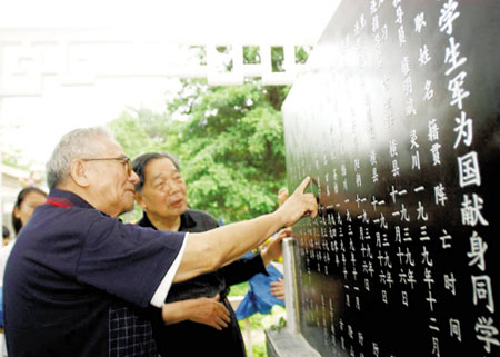 图为韦纯束(右一)等学生军老战士在纪念碑前缅怀战友.新华社发
