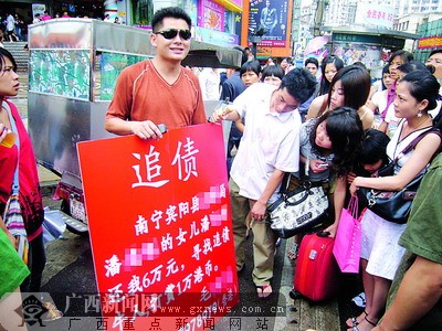 街头举牌追债?市民认为作秀!