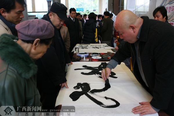 著名书法家张美中先生(右)为南宁市民挥毫泼墨书写作品