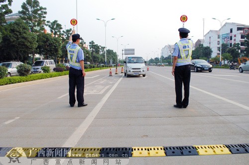 民警在来宾市迎宾桂中路口设卡截停一辆严重超员的微型车.
