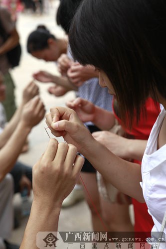 夫唱妇随,你穿针来我引线.广西新闻网记者 潘毅摄