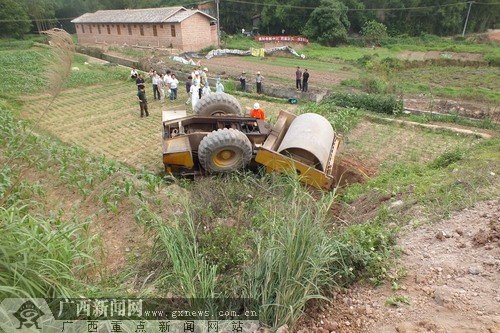 路口发生1辆压路机翻下路边斜坡的耕地,造成驾驶员被困,事故发生后