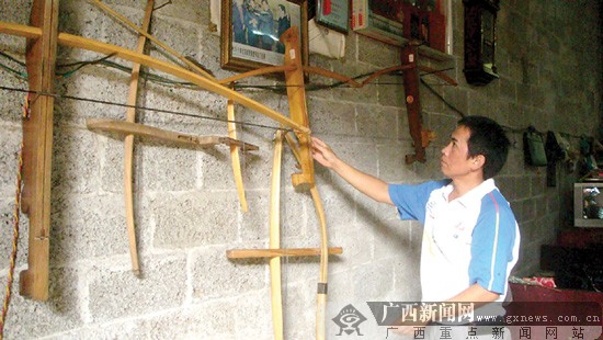 村里射弩比赛中,参赛选手正在拉弦装箭.