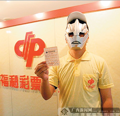 578万元大奖得主戴着面具出示中奖彩票广西新闻网讯 (记者 陈晓川