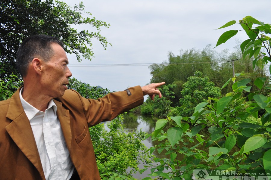 李益民在规划社区下一步要建的拱桥和凉亭.广西新闻网记者 覃 雄 摄