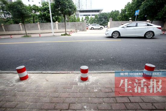 南宁部分路段人行道边沿试行隔离墩"站岗"