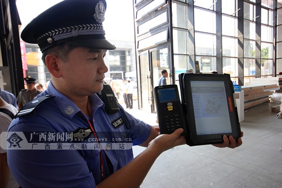 民警展示第二代身份证识别仪及公安网专用警用平板电脑.