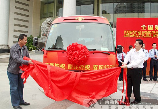 广西地税局局长关礼(右一),总会计师朱伟明为税法宣传大篷车活动