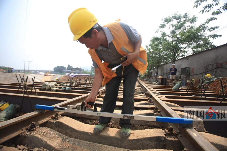 负责测量的工人要将铁轨的轨距精确到毫米.