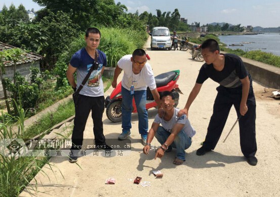 被拷上两副手铐的嫌疑人在指认赃物.广西新闻网通讯员杜小律 摄