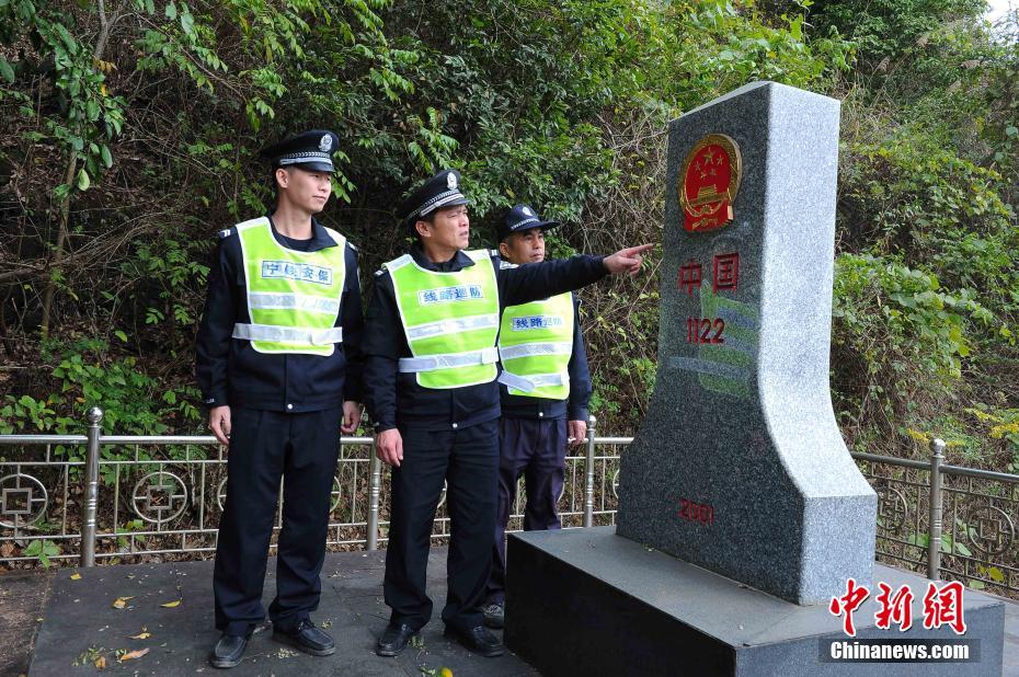 陆日峰(中)在中越1122号界碑前和同事交流.这里是湘桂线铁路的终点.