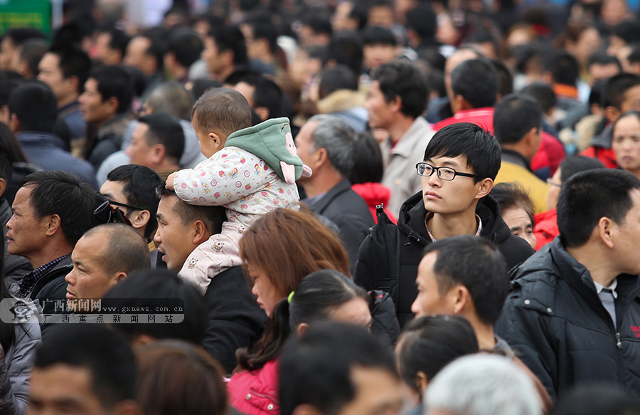 2月8日,在柳城县中心广场,一名男青年在前来求职的人群中徘徊.