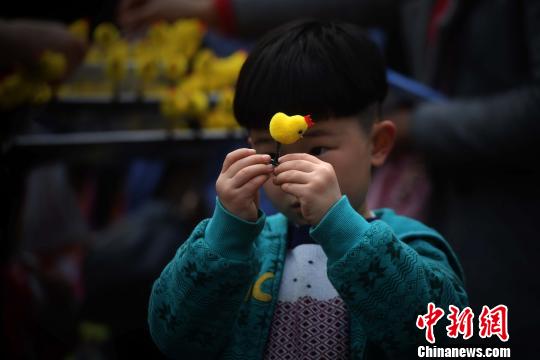 图为一小男孩购买小鸡饰品. 陈超 摄