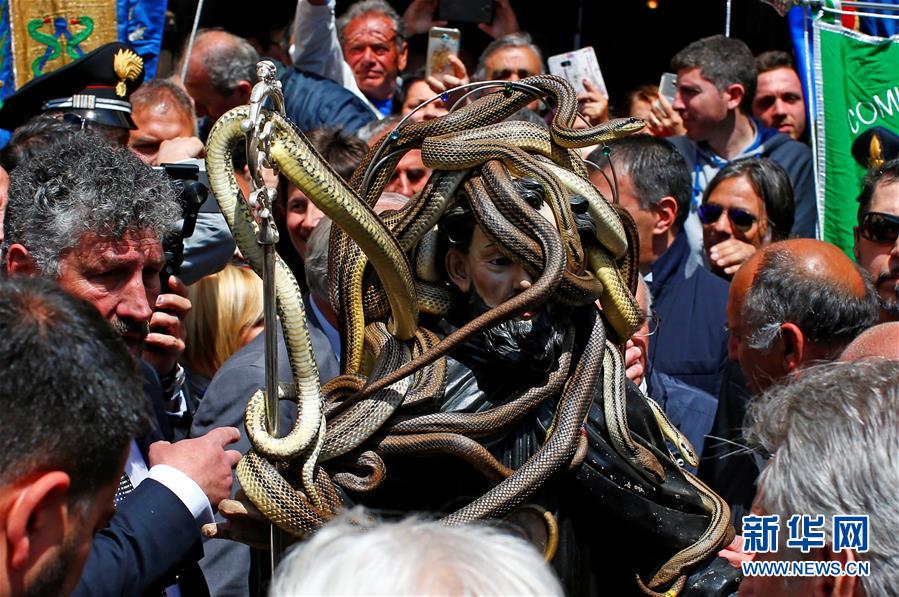 5月1日,在意大利中部城市科库洛,人们纷纷把蛇缠放在圣多米尼克的木雕