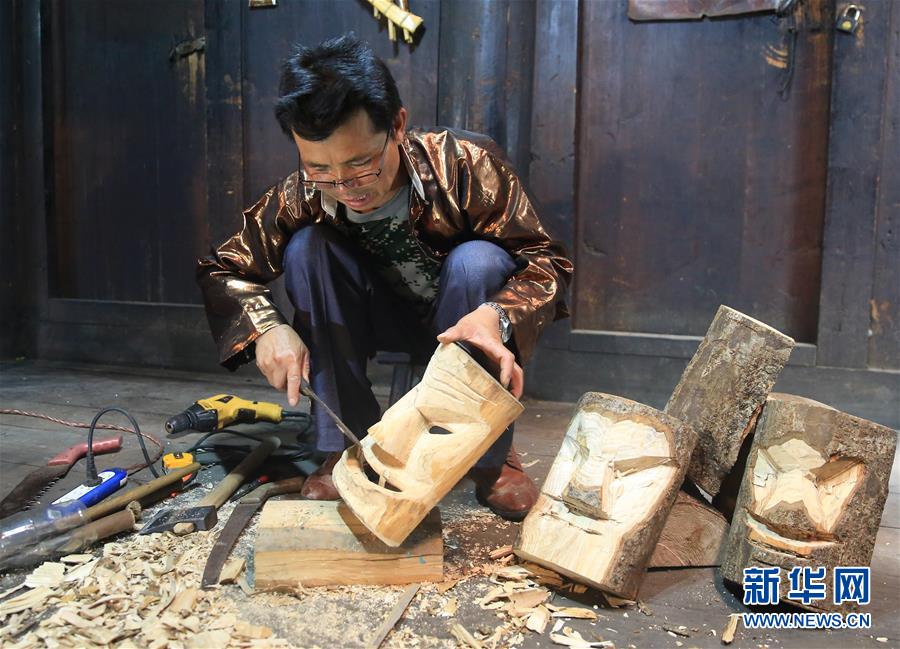 7月22日,在广西柳州市融水苗族自治县安陲乡吉曼苗寨,梁荣华用凿子锛