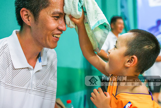 在赛场外为爸爸加油的小朋友,为走下赛场上的爸爸擦汗,好一个贴心娃!