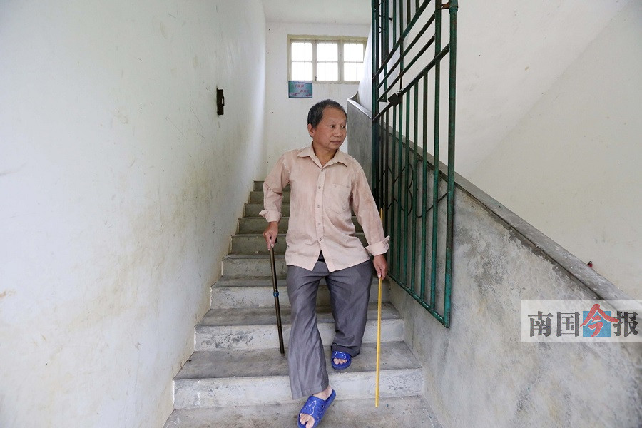 李朝文拄着拐杖去上课.通讯员 谭凯兴 摄