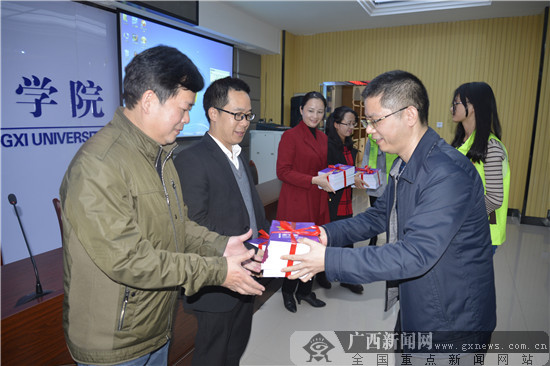 图为广西保监局向各承办学校赠送进校园书籍.