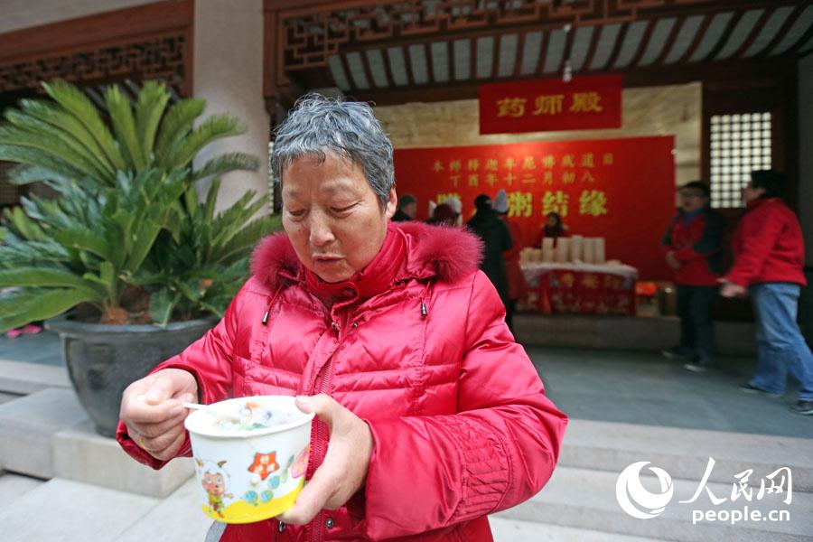 市民朱阿姨展示刚领取到的腊八粥.